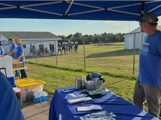 Hamilton employee standing at a hamilton booth at an event